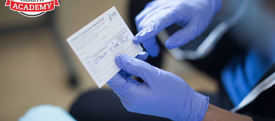 clinician holding vaccine card showing patient