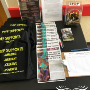 table with folded t-shirts and one-page brochure