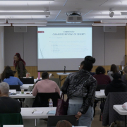 Participants viewing a slide presentation in a room